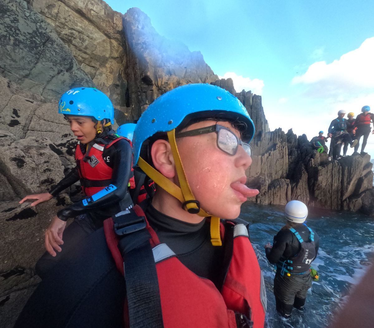 Young person on the rocks — grinning