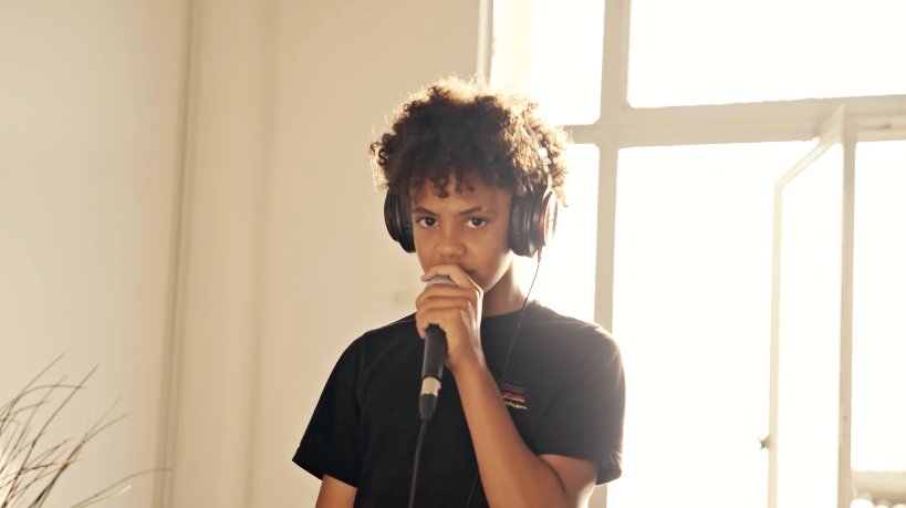 Young person performing with headphones and mic