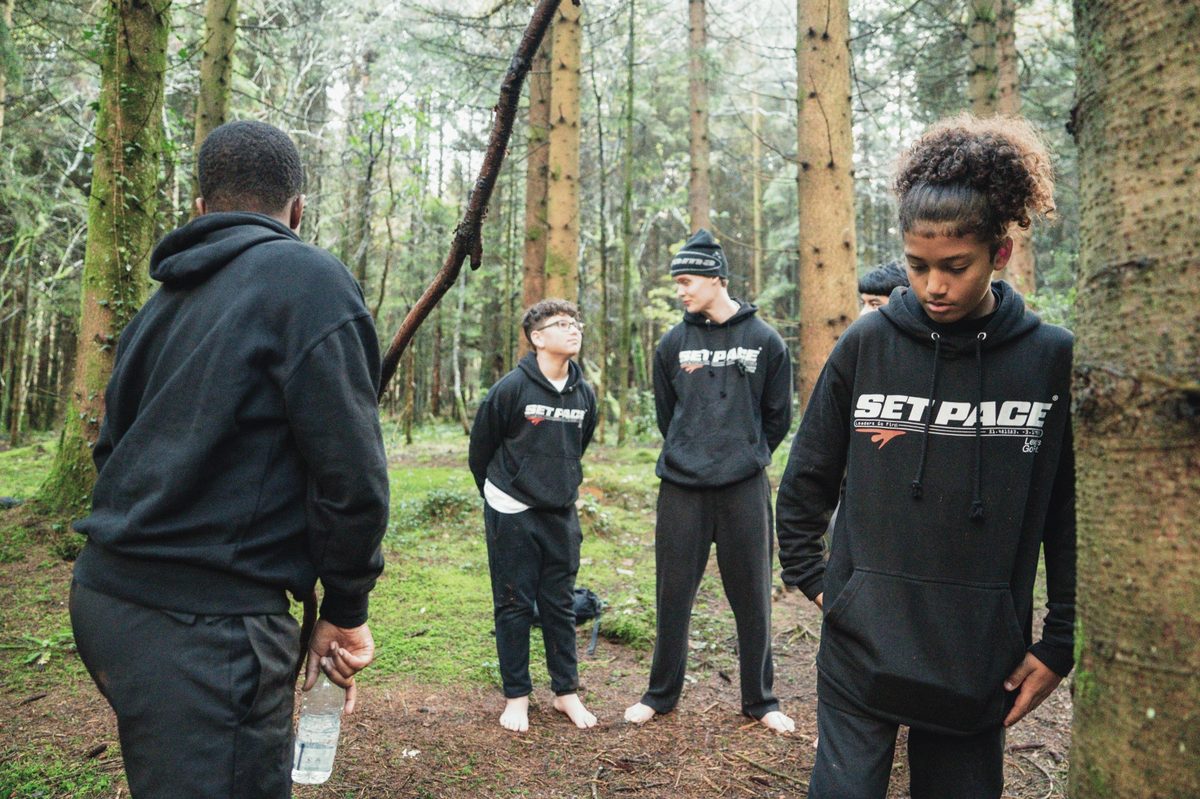 Set Pace young people standing barefoot in the forest — grounding exercise on a residential trip
